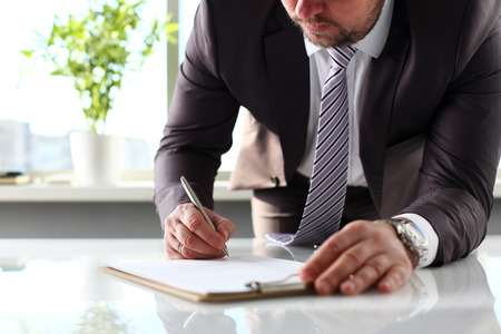 Male arm in suit and tie fill form clipped to pad