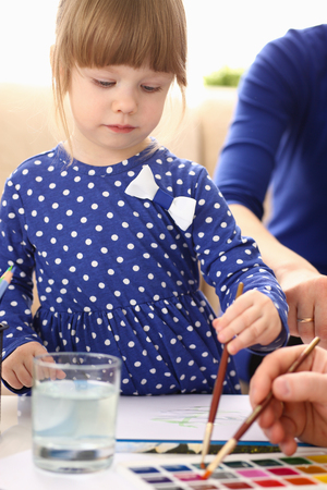 Blond smiling little girl hold in arm brushの写真素材