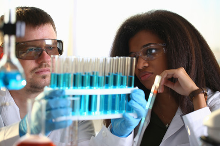 A male chemist holds test tube of glassの写真素材