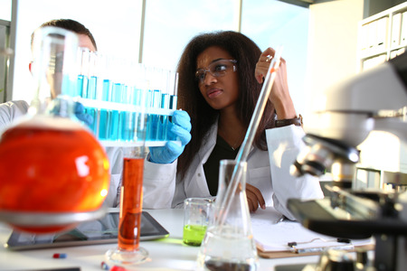 A male chemist holds test tube of glass