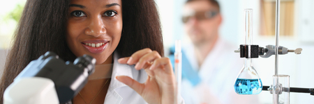 A male chemist holds test tube of glass