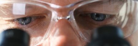 Male scientist looking through binocular