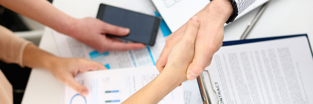 Man in suit shake hand as hello in office closeup