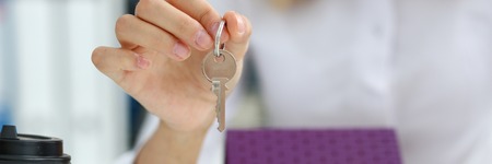 Female hand holds the key to the lock in the handの写真素材