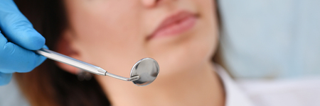 A woman at the reception of a male dentist examining