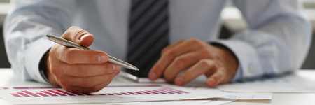 Hand of businessman in suit filling and signing with