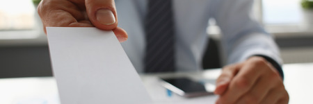 Male arm in suit give blank calling card to visitorの写真素材