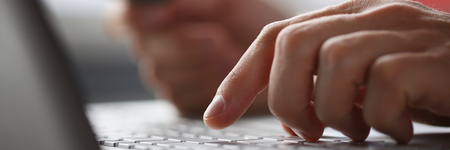 Male arms hold credit card press buttons makingの写真素材