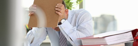 A man experiences stress and a headacheの写真素材