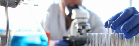 A male chemist holds test tube of glass in his handの写真素材