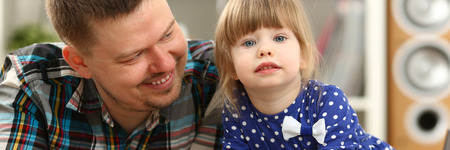 Cute little girl on floor carpet with dadの写真素材