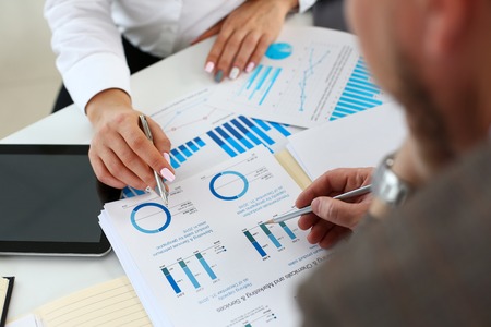 Female arm holding silver pen point in financial graphの写真素材