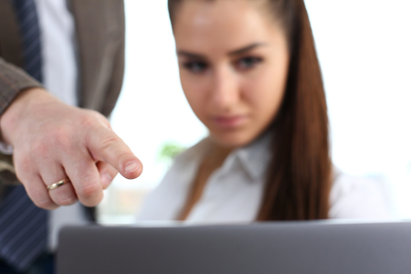 Male arm show finger to laptop pc in officeの写真素材