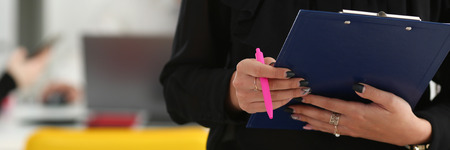 Brunette woman hold in arms pink pen and paperの写真素材