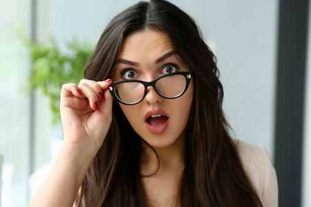 Young beautiful business woman holding glassesの写真素材