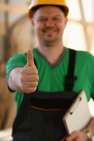 Smiling worker in yellow helmet show confirm signの写真素材