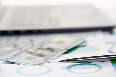 Silver pen lying on desk cash dollar plotsの写真素材