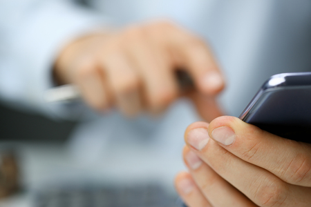 Businessman in the office dials the numberの写真素材