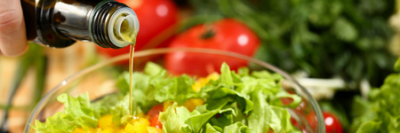 Cook holds bottle in hand and trickles oliveの写真素材