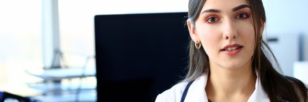 Beautiful smiling female doctor sit at workplaceの写真素材