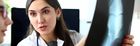 Female white doctor hold in arm and lookの写真素材