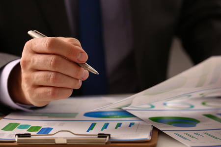 Male hand in suit hold siver pen in officeの写真素材