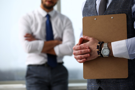 Male clerk arm in suit and tie with paper clipped to padの写真素材