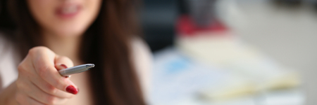 Female arm in suit hold silver pen and padの写真素材