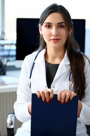 Beautiful smiling female doctor at workplace portraitの写真素材