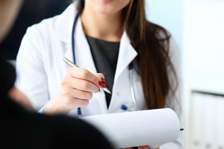Female doctor hand hold silver pen fillingの写真素材