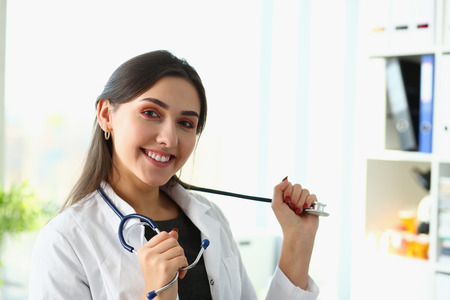 Beautiful smiling female doctor at workplace portraitの写真素材