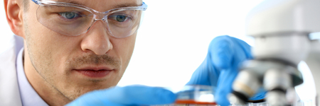 A male chemist holds test tube of glass in his hand