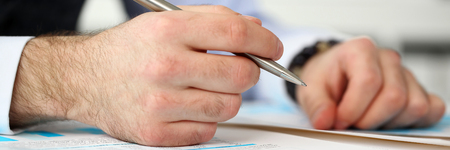 Clerk man at office workplace with silver pen in armsの写真素材