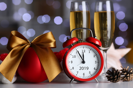 Red alarm clock and champagne goblet at office tableの写真素材