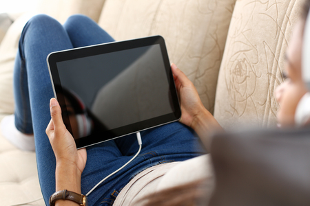 Feale hand holds tablet in home setting whileの写真素材