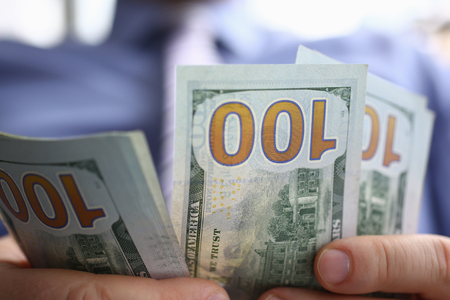 The businessman considers cash dollars in the officeの写真素材