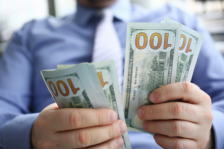 The businessman considers cash dollars in the officeの写真素材