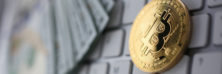 Coin crypto currency bitcoin lies on the keyboard background theme gold exchange pyramid for money due to rise or fall exchange rate closeupの写真素材
