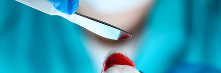 Surgeon in sterile uniform arms holding and passing to colleague tools with bio material wad closeup while operating patient. Stop bleeding put stitch er 911 conceptの写真素材