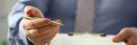 Male arm in suit offer contract form on clipboardの写真素材