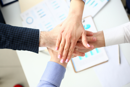 Group of people in suits crossed hands