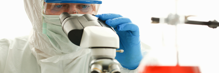 Male chemist in blue protective gloves look