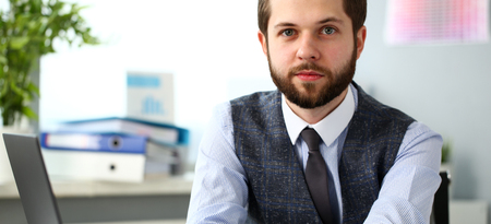 Handsome smiling bearded clerk man at office workplaceの写真素材