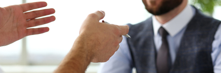 Two clerk businessmen with silver pen in arms deliberate on problem