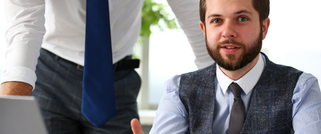 Group of businessmen point arm with silver pen at laptop pcの写真素材