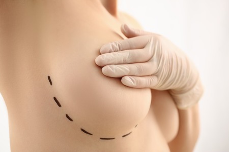 Female hand in gloves holding breast closeupの写真素材
