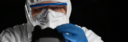 Male chemist in blue protective gloves look