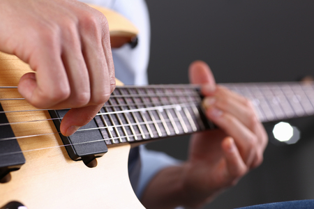 Male arms playing classic shape electric guitarの写真素材