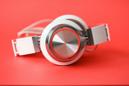 White headphones on coral background
