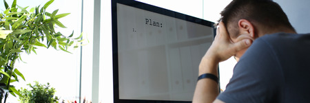 Sad upset male worker hold his head solving business problem